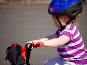 little girl wearing scooter helmet